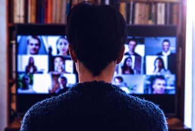Woman in front of a device screen in video conference