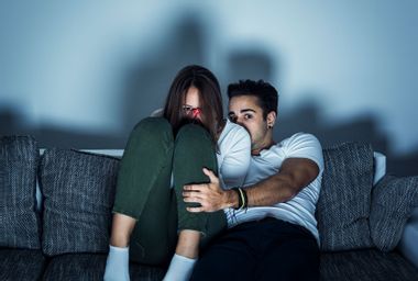 Couple watching scary movie on the couch