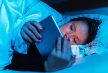 Woman using tablet pc in bed