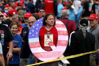 A man holds a large "Q" sign while waiting in line on to see President Donald J. Trump at a 2018 rally in Pennsylvania.