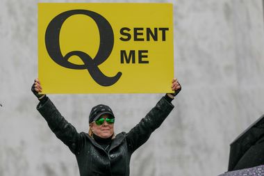 A QAnon supporter holds a sign during a protest at the Oregon State Capitol in Salem on May 2, 2020.
