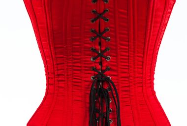 The back of a red corset with black laces