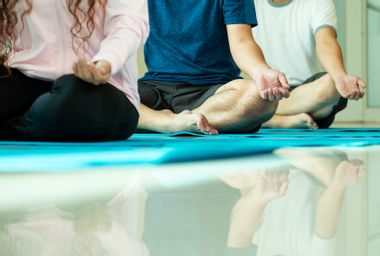 Close-up of three people practicing yoga meditation