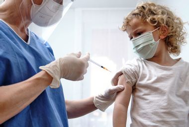 Female doctor giving covid-19 vaccine to a toddler