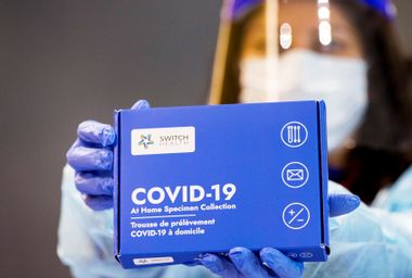 A medical worker shows a COVID-19 At-Home Specimen Collection kit