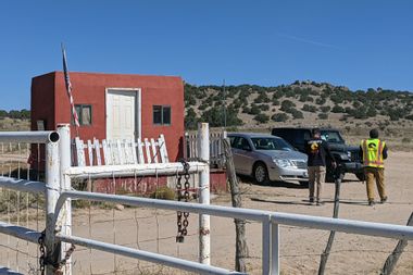 A security guard speaks to a person from the Office of the Medical Investigator at the entrance to the Bonanza Creek Ranch on October 22, 2021 in Santa Fe, New Mexico.