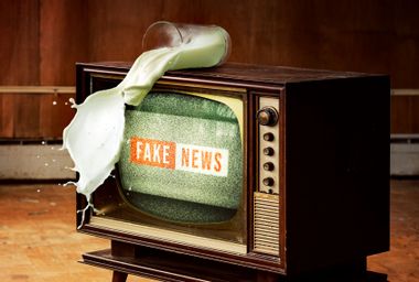 Spilled milk on a television showing the text "FAKE NEWS"