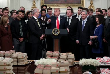 U.S. President Donald Trump speaks behind a table full of McDonald's hamburgers, Chick fil-a sandwiches and other fast food