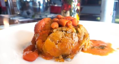 Mofongo, made from fried mashed green plantains with garlic. salt and pepper mixed with pork cracklings, then shaped into a ball. Served with red beans.