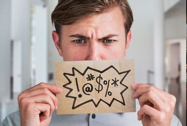 Man holding a swear word sign in front of his mouth