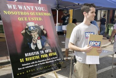 A Republican Party volunteer standing next to a voter registration poster at Carnival Miami.