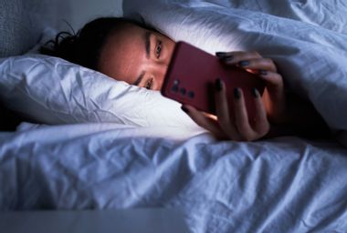 Lady on smartphone in bed