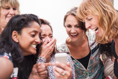 A group of women laughing at their smartphone