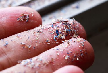 Close up side shot of microplastics lay on a person's hand