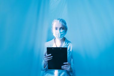 Female doctor with clipboard isolated with blue plastic drapes