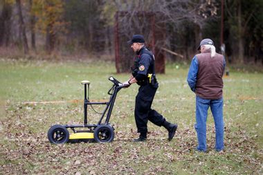 A Six Nation police officer uses a ground-penetrating radar machine on the grounds of the former Mohawk Institute Residential School, in Brantford, Canada