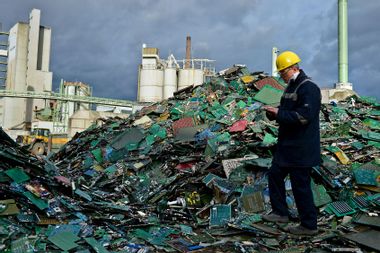 Electronic components including circuit boards sit in a pile ahead of recycling