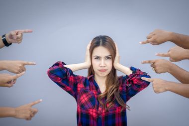 Woman being judged by different people pointing fingers at her