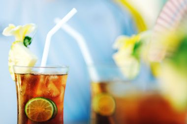 Glasses of iced tea with straws and tropical garnishes