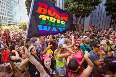 Woman waving a Born This Way rainbow flag