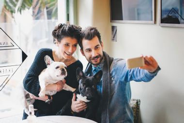 A couple taking a selfie with their dogs