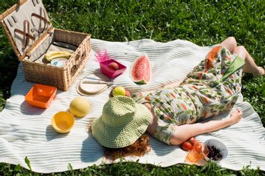 Young woman lying on picnic blanket