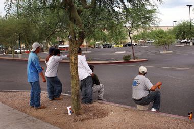 Immigrants from Mexico and Central America await day labor work on a curbside near a Home Depot in Phoenix, Arizona.