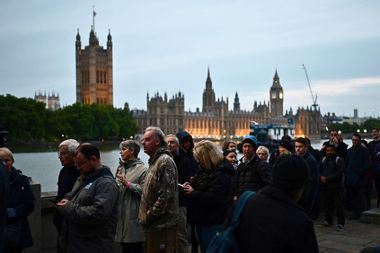 Members of the public queue along the South Bank of the River Thames, opposite the Palace of Westminster, as they wait in line to pay their respects to the late Queen Elizabeth II