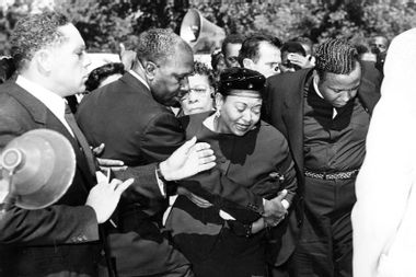 Mrs Mamie Bradley (center) reacts as the body of her son, Emmett Till, is lowered into his grave during the funeral, September 1955