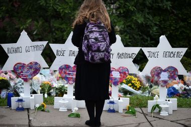 A woman stands at a memorial outside the Tree of Life synagogue