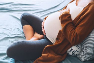 Pregnant woman sitting in bed