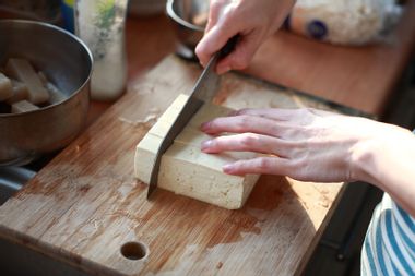 Cutting tofu on the chopping board