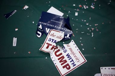 Torn posters litter the floor following a campaign rally with Republican presidential candidate Donald Trump
