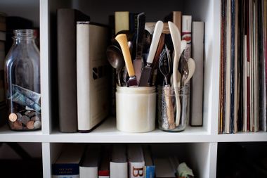 Cutleries in containers on bookshelves