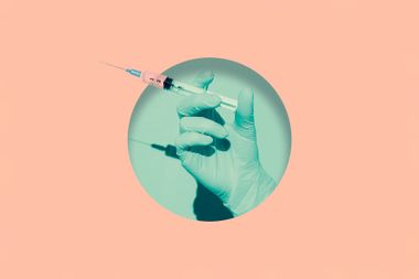 Doctor's hand holding syringe of vaccine
