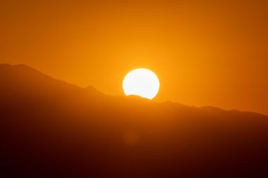 Sun rises over mountains as seen from the Griffith Observatory in Los Angeles, California
