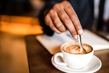 Man mixing coffee hand close up