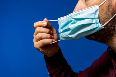 Man taking off his surgical mask