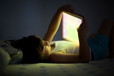 5 year old boy using a digital tablet in the dark