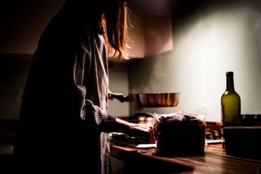 A woman cooking at night in the kitchen