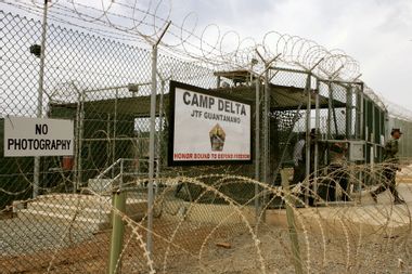 A Soldier walks through a gate at Camp Delta at Guantanamo Naval Base in Guantanamo, Cuba. 