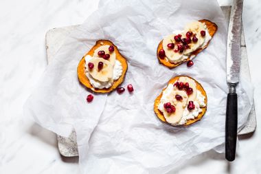 Toasted slices of sweet potato with cottage cheese, banana and pomegranate seeds