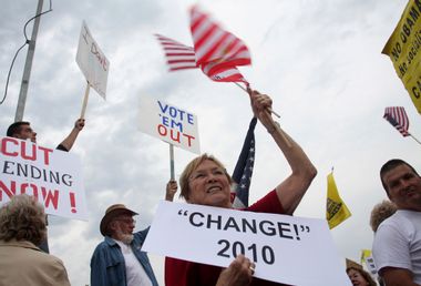 People hold signs during a "tea party" protest in Flagstaff, Arizona