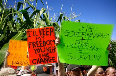 People wave signs at a "tea party" protest on the grounds of the Colorado tate capitol in Denver