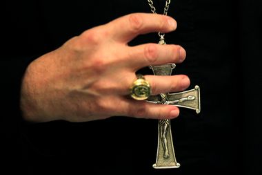 A bishop grasps his pectoral cross during the United States Conference of Catholic Bishops in Baltimore