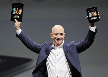 Amazon CEO Bezos holds up the new Kindle Fire HD 7" and Kindle Fire HD 8.9" during Amazon's Kindle Fire event in Santa Monica