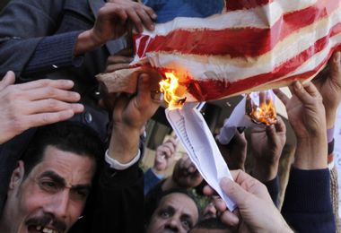 Protesters burn a mock U.S. flag, condemning the decision of the Ruling Supreme Council of the Armed Forces (SCAF) to release American activists who were involved in what is known as the NGO foreign fund case, in front of the U.S embassy in Cairo