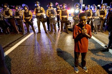 Amarion Allen, 11-years-old, stands in front of a police line shortly before shots were fired in a police-officer involved shooting in Ferguson
