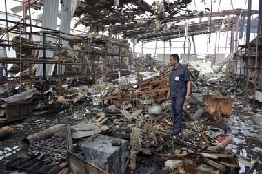 Worker stands at a beverages factory after it was hit by a Saudi-led air strike in Yemen's Red Sea port city of Houdieda