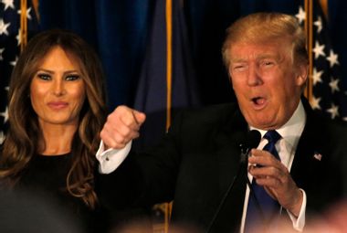 Republican U.S. presidential candidate Donald Trump reacts on stage as his wife Melania looks on at his 2016 New Hampshire presidential primary night rally in Manchester